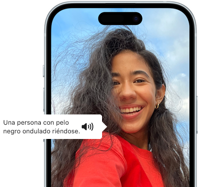 Un iPhone 15 que muestra cómo la prestación VoiceOver lee la información de la imagen: una persona con pelo negro ondulado riéndose